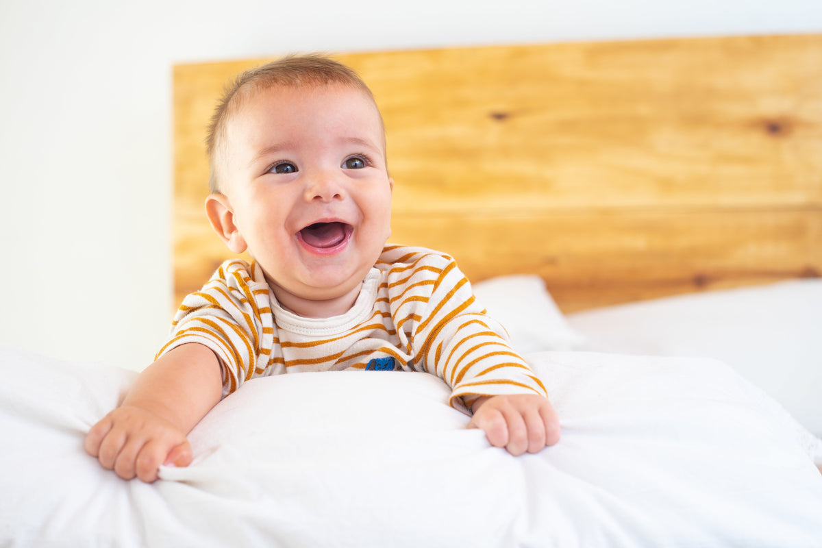 Bebé sonriente tumbado en la cama