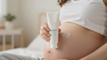 Mujer embarazada aplicando crema en su vientre.