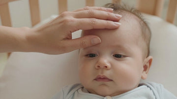 Padre tocando la frente de su bebé con fiebre.