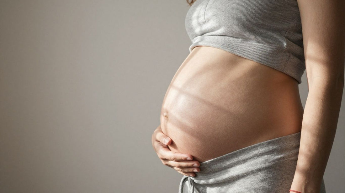 Mujer embarazada de 30 semanas acariciando su vientre.