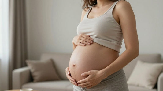 Mujer embarazada acariciando su vientre en casa tranquila.