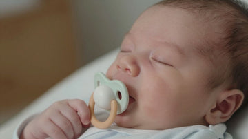 Bebé durmiendo con un chupete suave.