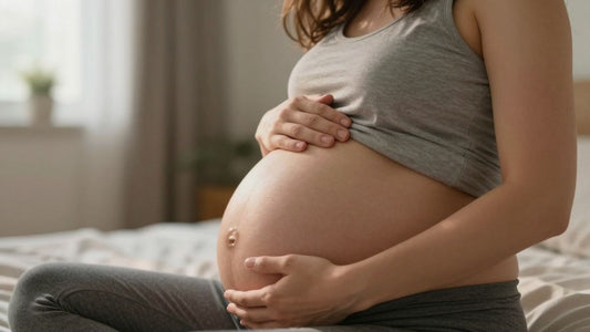 Pregnant woman holding her lower back in discomfort.