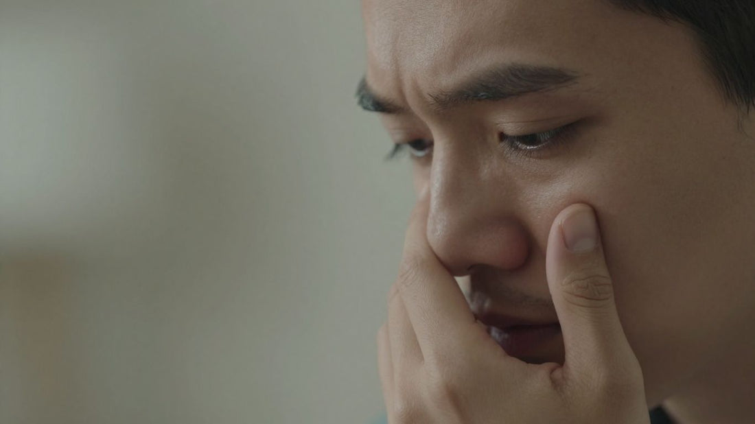 Persona tocando su sien con preocupación.