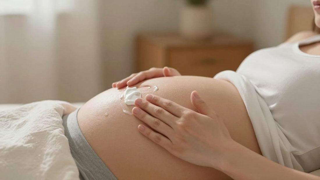 Mujer embarazada aplicándose crema en el abdomen.