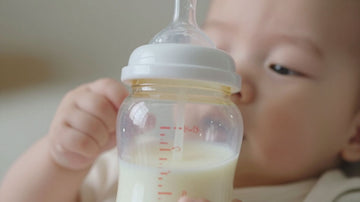 Bebé con biberón de leche sin lactosa.