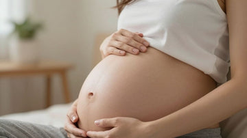 Mujer embarazada tocando su vientre con ternura.