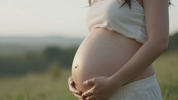 Mujer embarazada tocando su vientre con esperanza.