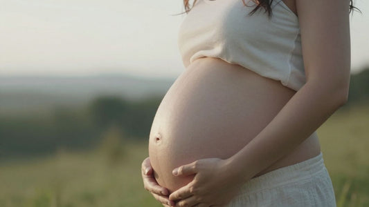 Mujer embarazada tocando su vientre con esperanza.