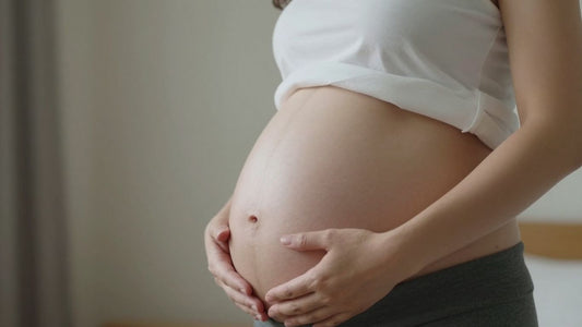 Mujer embarazada en la semana 33, acariciando su vientre.