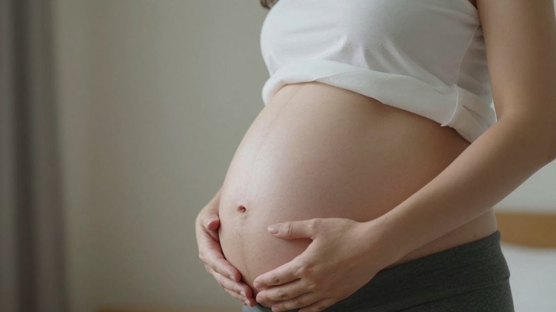 Mujer embarazada en la semana 33, acariciando su vientre.