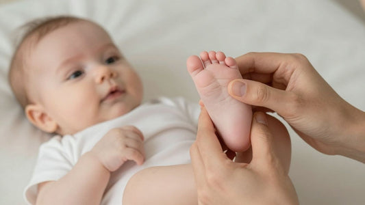 Padre masajeando los pies de su bebé con ternura.
